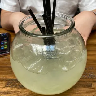 a person sitting at a table with a glass of lemonade