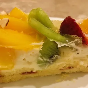 Fruit flan slice showing all the different components and layers.