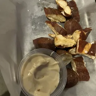 a plate of pretzels and a cup of sauce