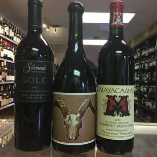 three bottles of wine on a counter