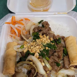 Vermicelli noodles with stir fry beefand egg rolls.