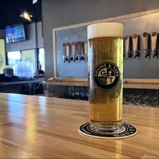a glass of beer on a bar