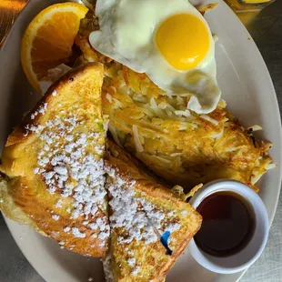 a plate of french toast with an egg on top