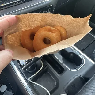 1/2 dozen glazed donuts in a a paper bag.