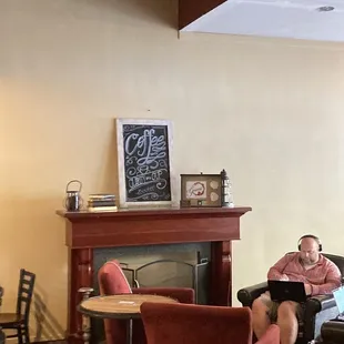 a man sitting on a couch in front of a fireplace