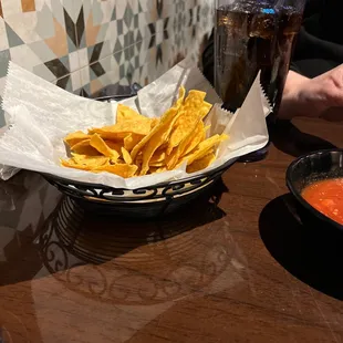 a bowl of chips and a drink