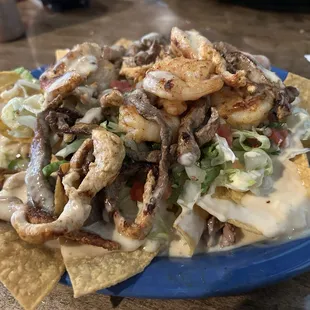 Shrimp, steak and chicken nachos. It's delicious!!  Easy on the sauce so you can actually taste the food.