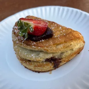a stack of pancakes on a paper plate