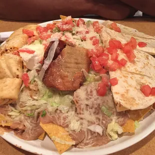 appetizer platter... flautas, nachos, and cheese quesadillas with guac and sour cream. lots of chips, but there&apos;s plenty of topping for it