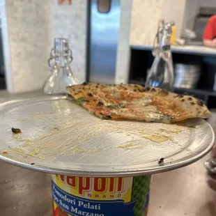 a half eaten pizza on a pan