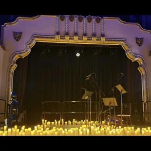a stage with candles and a piano