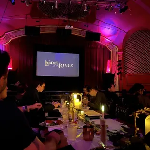 a group of people sitting at a long table