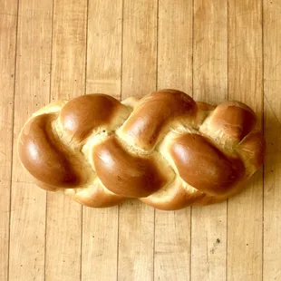 a braided loaf of bread on a wooden surface