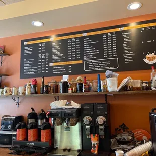 a coffee shop with a menu on the wall