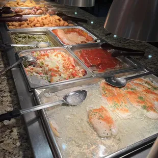a variety of food being served at a buffet