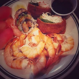 a plate of food with shrimp, watermelon, and sushi