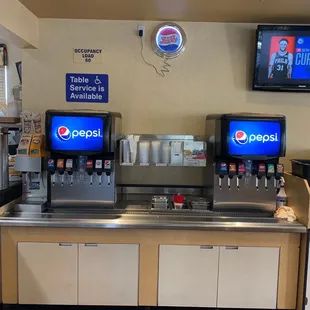 a soda machine and televisions