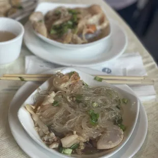 two plates of food on a table with chopsticks