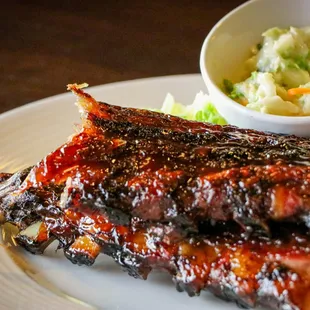 a plate of ribs and coleslaw