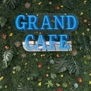a sign surrounded by plants and flowers
