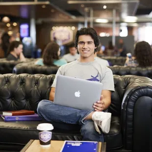 a man sitting on a couch with a laptop