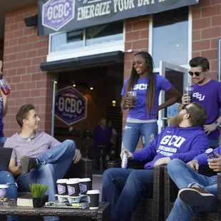 a group of people sitting outside of a bar