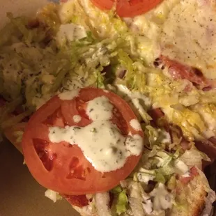 a slice of pizza with tomatoes and lettuce