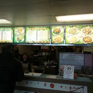 a man standing at the counter of a restaurant