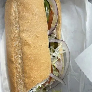 a sub sandwich with onions and lettuce