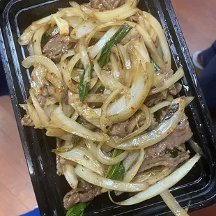 beef and onions in a black container