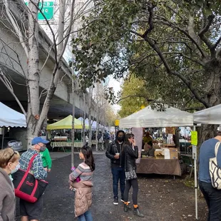 people shopping under a bridge