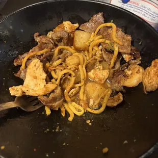a plate of noodles and meat
