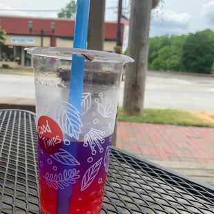 a drink in a plastic cup with a blue straw