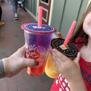 a little girl holding a cup of frozen drink