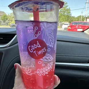 a hand holding a cup with a straw