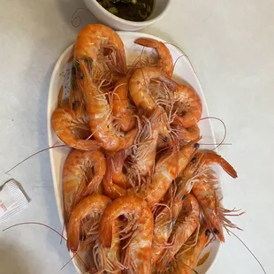 a plate of shrimp and a bowl of dipping sauce