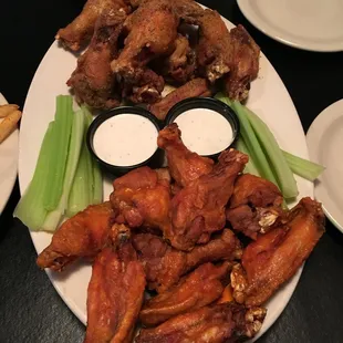 a plate of chicken wings and celery sticks