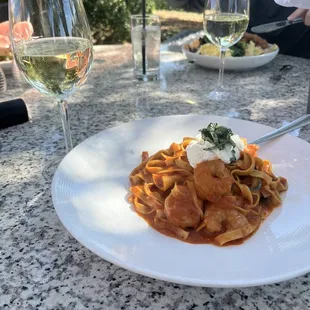a plate of pasta and a glass of wine