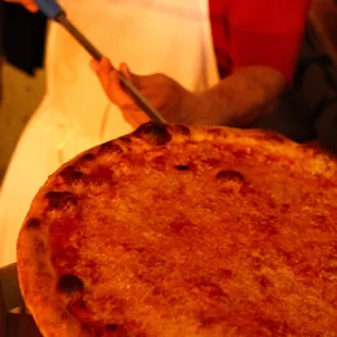 a person cutting a pizza