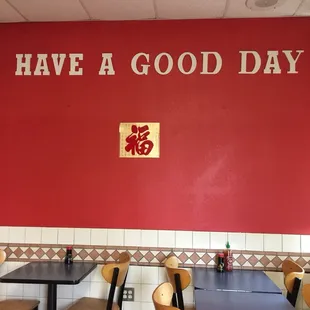 a red wall with a sign that says have a good day