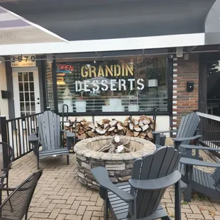 a patio with chairs and a fire pit