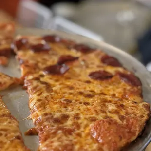 a pepperoni pizza on a pan