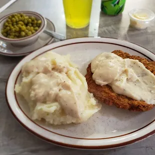 Chicken fried steak, mashed potatoes, and peas