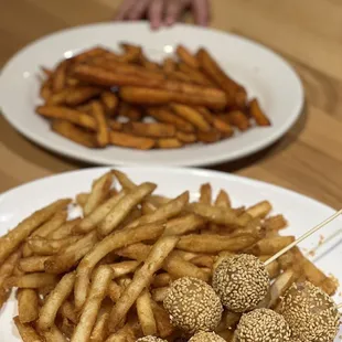 a plate of french fries and skewers