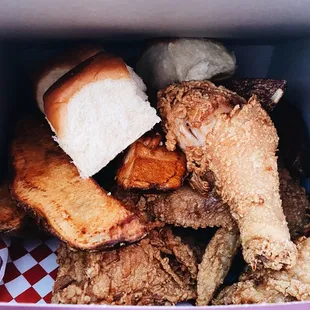State fair combo: mixed chicken, potatoes, and rolls.