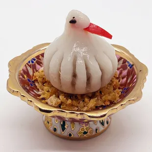 a small white bird in a decorative bowl