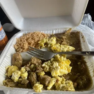 an open takeout container with a fork and some food in it