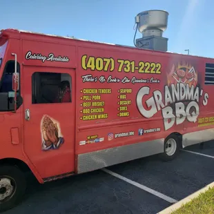a red food truck parked in a parking lot
