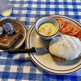 Chicken fried steak with poached eggs, tomatoes, and rye toast