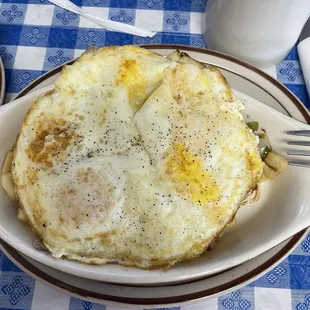 Breakfast scramble with breakfast potatoes ham green bell peppers mushroom onion &amp; Monterey Jack cheese, covered by 2 eggs over medium